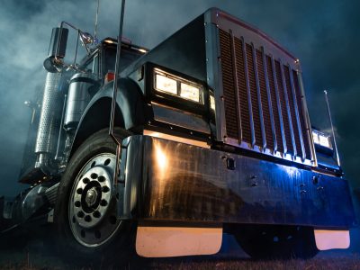 Retro Semi Truck Tractor Night Time Bluish Illumination and Foggy Atmosphere. Trucking Concept. Transportation Industry Theme.